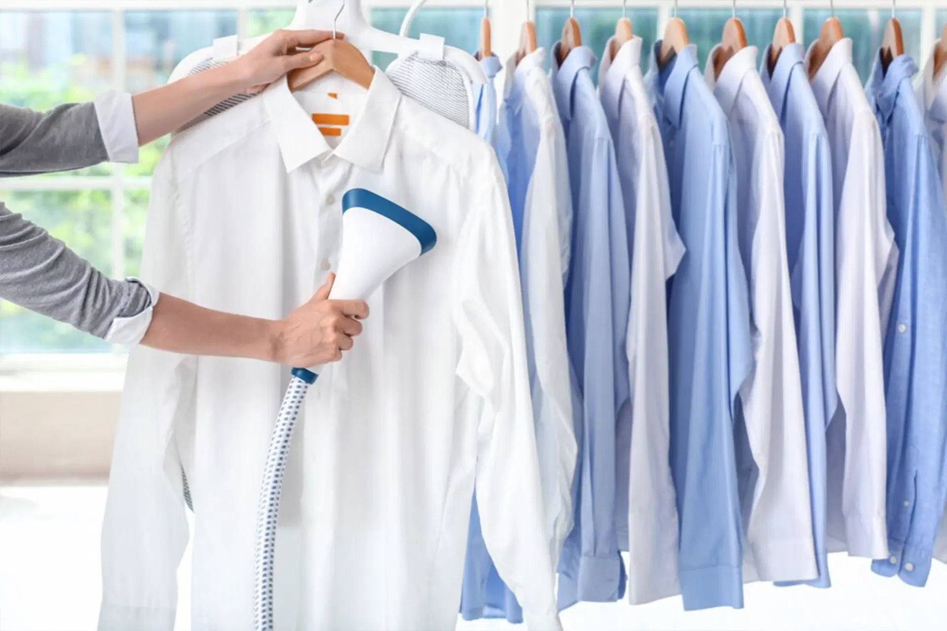 Photo: white and navy dress shirts on wooden hangers in a closet